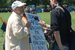 Man with medical marijuana sign is being interviewed