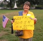 Woman holding sign saying "Keep my son in his home."