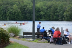 view of bench, people and pond