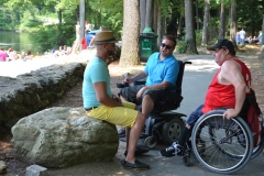 three people talk in the shade