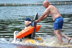 man gets pushed into the pond in a floating beach chair