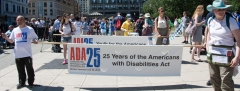 marchers with banner - 25 years of the americans with disabilities act