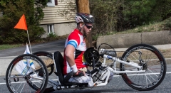 side view of a man racing a handcycle