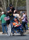 smiling man pushing smiling young man in wheelchair