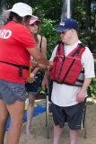 DCR staff helps one person with his life jacket