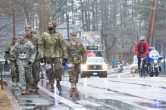 photo of military walkers, as trucks for first women come up behind them.
