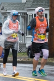 Photo of a mobility impaired man with a guide and a shower cap on. His tee shirt says "I run to stop ms"