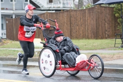 Photo of a man pushing another man in a wheelchair.