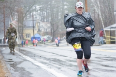 Photo of early start woman. She is missing a hand and wearing a garbage bag.