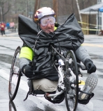 Photo of a handcycle racer wearing a particularly wingy-looking trash bag.