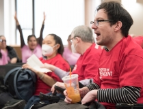 Man with BCIL shirt yelling indoors