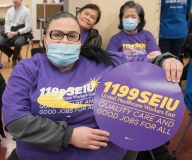 Woman with 1199SEIU sign indoors