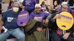 Several people with 1199SEIU signs indoors