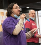 Young man rallies the crowd (indoors)