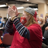 Woman in baseball cap cheering (indoors)