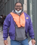 Man with orange vest gets ready to help supporters across the street