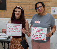 Two women with signs.  One sign says "People are Important", the second sign says "I care and everyone deserves a home. But who takes care of me. Currently Homeless."