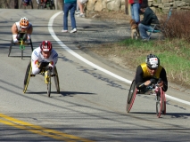 three wheelchair racers going downhill
