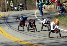 several wheelchair racers going downhill
