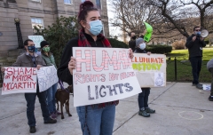 Protestors with signs: "Shame on Mayor McCarthy", "You're on the Wrong Side of History", Human RIghts Not Holiday Lights:," Illuminate History"