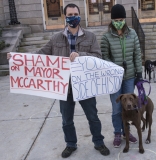 Protestors and dog: "Shame on Mayor McCarthy", "You're on the Wrong Side of History"