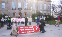 Protestors in front of Waltham City Hall.  Bill Henning speaking on the right.  Banners: Waltham, Mass Why do disabled people come last?