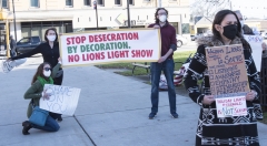 Protestors: banner: "Stop Desecration by Decoration. No Lions Light Show", "Shame on Your", Waltham Lions motto to serve - that means: Listening, Awareness, Empathy, Stewardship, Foresight, Building Community, Holiday Lights @ Fernald is not serving your community"