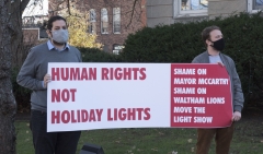 Two men with banner: Human Rights not Holiday Lights - Shame on Mayor McCarthy, Shame on Waltham Lions, Move the Light Show