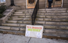 Sign on steps while woman calls the mayor: Illuminate History