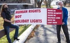 Bill and Maura with sign: Human Rights Not Holiday Lights - Shame on Mayor McCarthy, Shame on Waltham Lions, Move the Light Show
