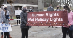 Protestors at Fernald - banner: "Human Rights not Holiday Lights"