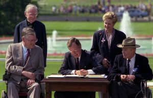 Bush signs the ADA in 1990. Kemp is seated to the left of Bush