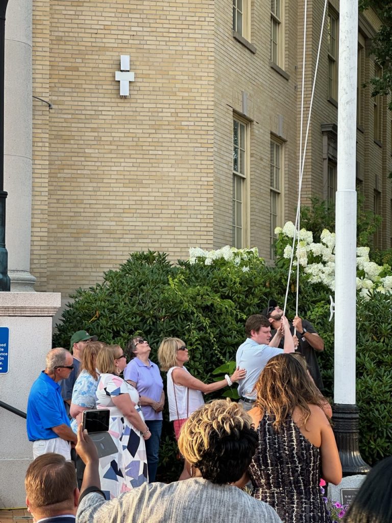 Framingham Disability Commission, including Rose Quinn (MWCIL) and Tyler Terrasi (MWCIL BOD) raise the new flag.