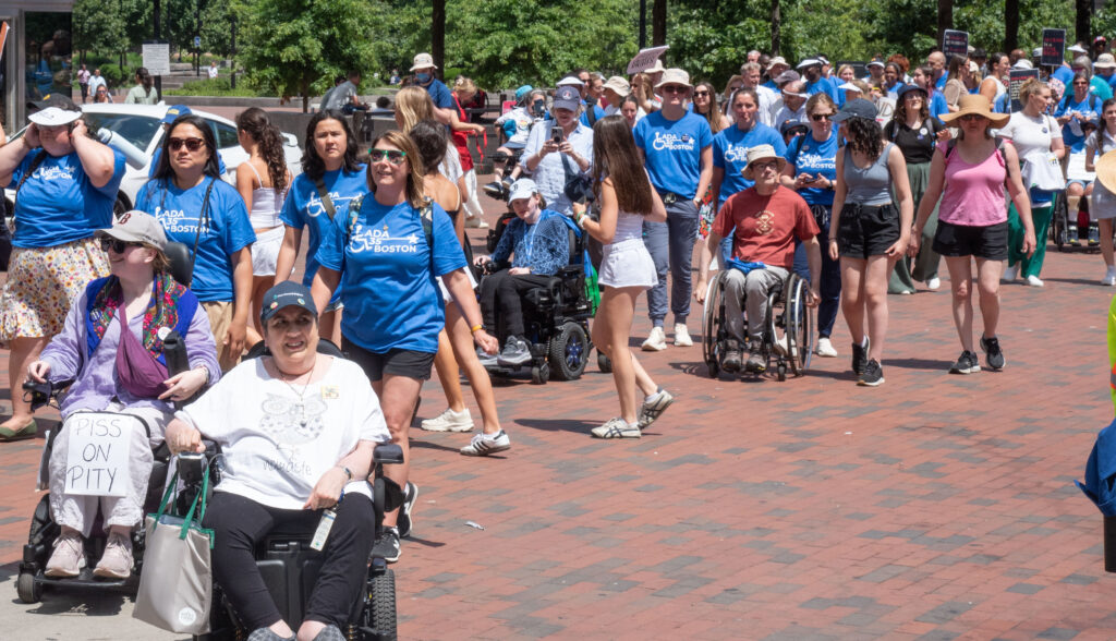 Marchers - 3 wheelchairs, one sign: Piss on Pity