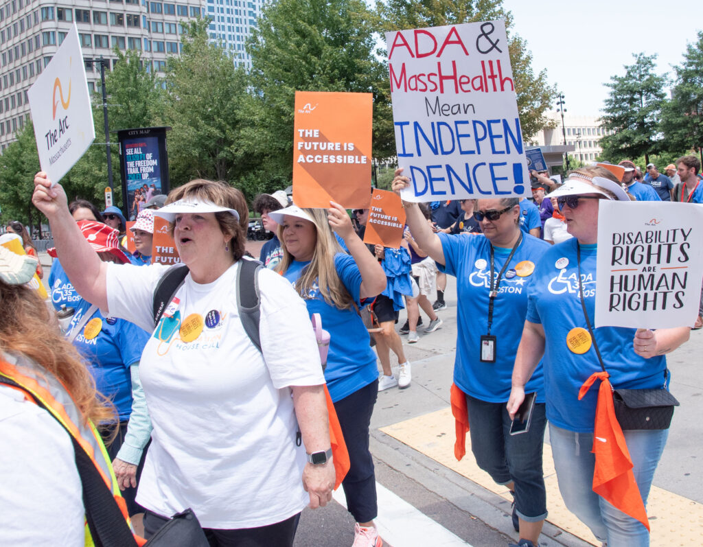 Marchers with signs: ADA & MassHealth mean Independence