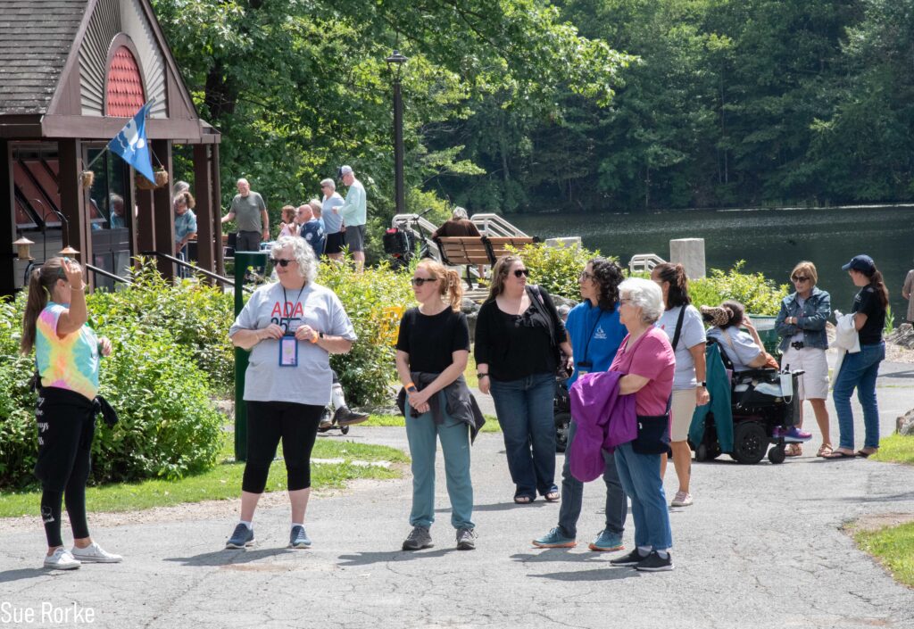 group of people on path in front of pond